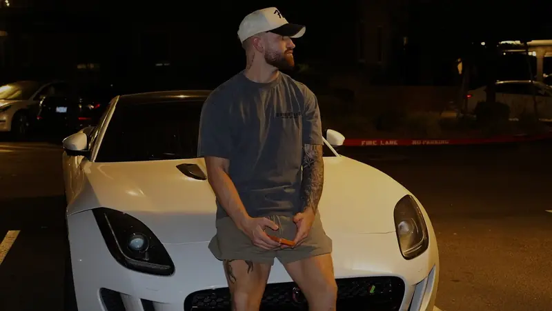 Caleb Hellinger in front of a white sports car